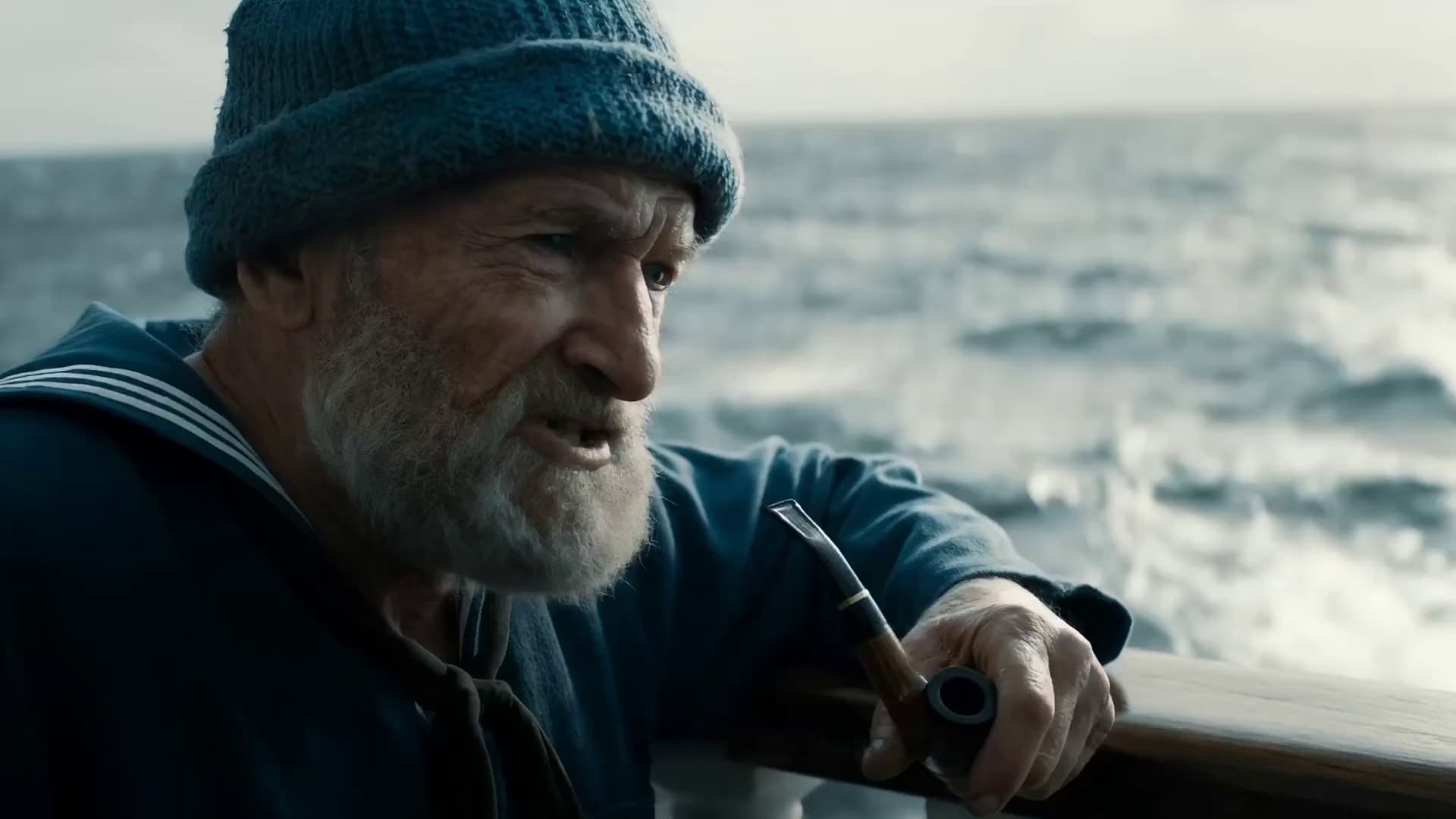 Old sailor with pipe on a ship looking at the sea